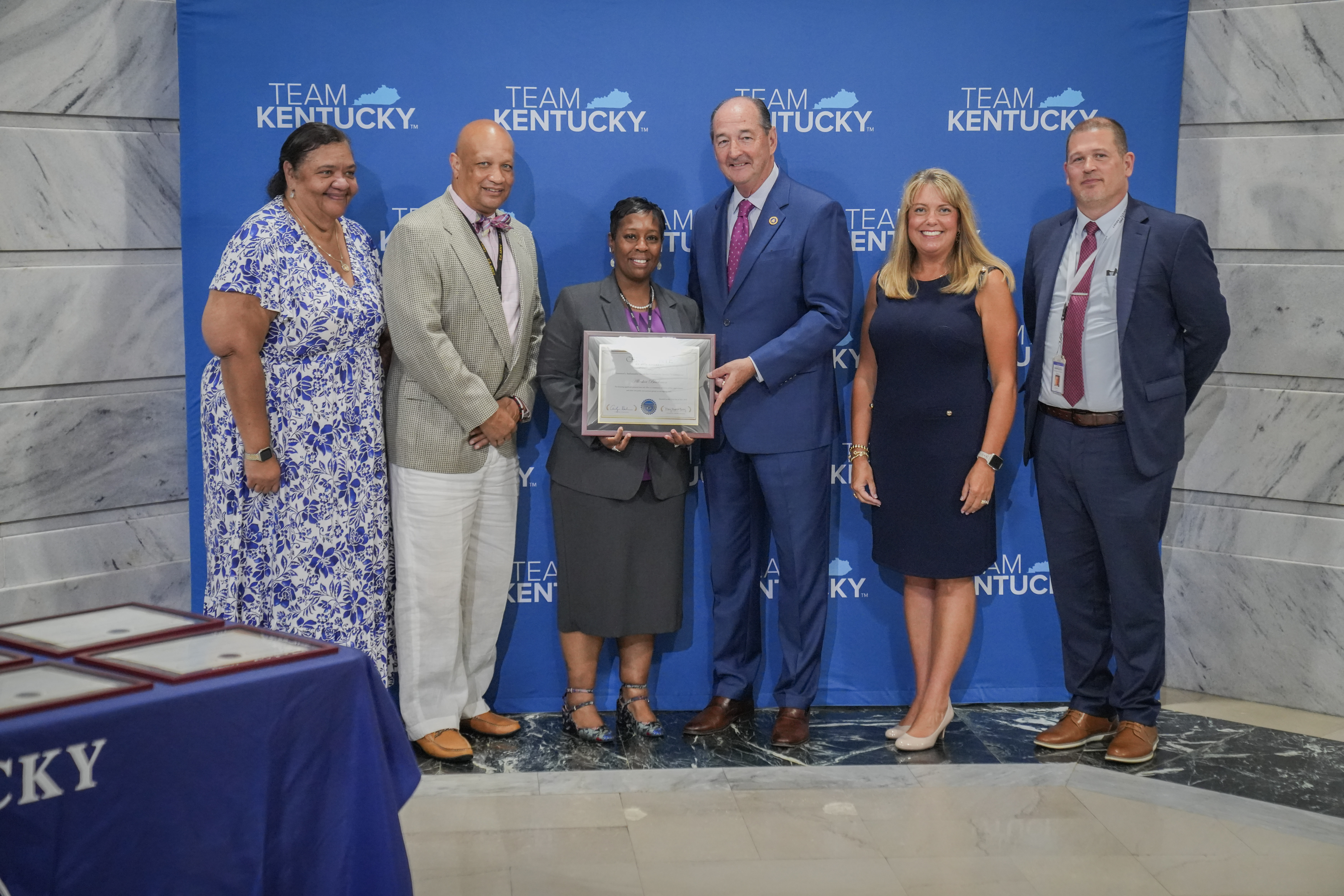 Amy Carder and family recieving Community Service and Volunteerism Award from Governor Andy Beshear and Secretary Bailey